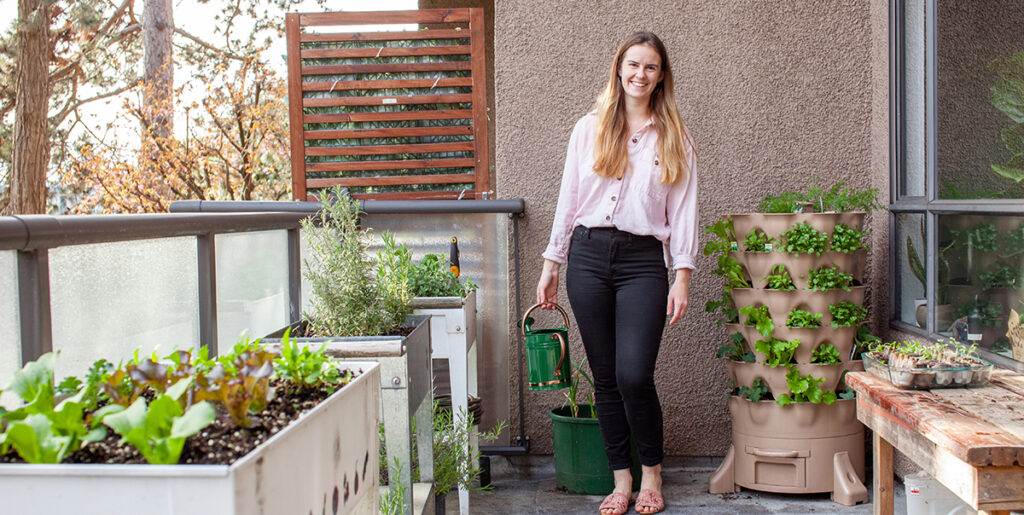 a young blonde woman is planting a vertical tower garden with he